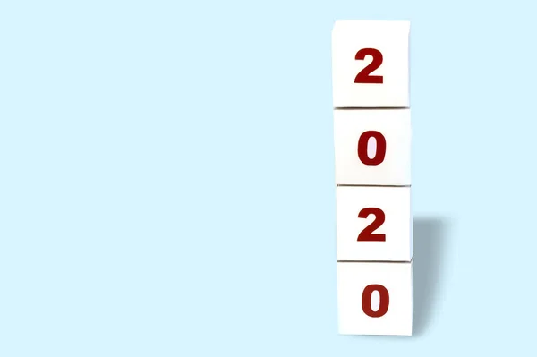Happy new year 2020 on a cubic white paper block on a bright blue background, happy new year 2020 greeting card, banner. Copy space — Stock Photo, Image