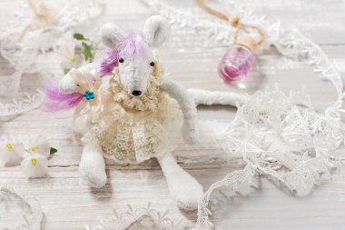 Dantel ve çiçeklerle dolu bir masada elbise li sevimli beyaz sıçan. Özel oyuncak, el yapımı, yaratıcı, kendiniz yapın. Doğu takviminde sembol 2020