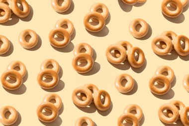 Şeftali rengi arka plan üzerinde simit desen . Fırın ürün şablonu, geleneksel Rus ekmek ürünü. Yaratıcı düzen. Üstte görüntü