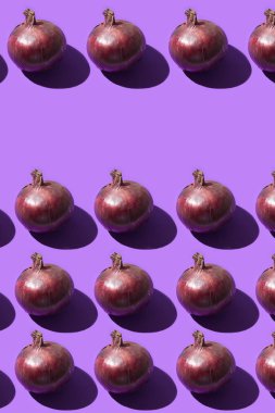 Mor bir arka plan üzerinde kırmızı soğan, salata ve yemekler için tatlı soğan