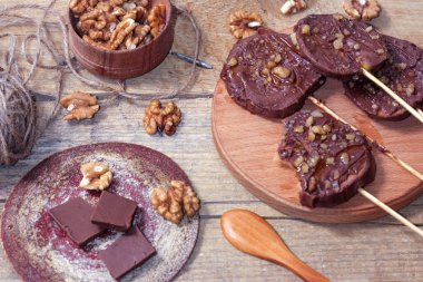 Ahşap bir arka plan üzerinde şişler üzerinde çikolata, karamel sır ve ceviz elma dilimleri