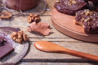 Ahşap bir arka plan üzerinde şişler üzerinde çikolata, karamel sır ve ceviz elma dilimleri