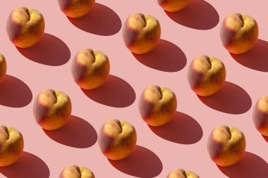 Pastel pembe arka plan üzerinde birçok sulu olgun şeftali bir desen. Yaratıcı düzen