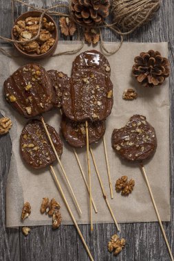 Koyu bir arka plan üzerinde şişler üzerinde çikolata, karamel sır ve ceviz elma dilimleri