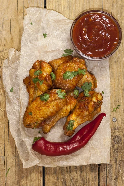 Kızarmış sulu tavuk kanatları bal, soya sosu, baharat, ince doğranmış kişniş ile bir kağıt arka plan serpilir marine. Asya tarifi, üstte, yakın çekim.