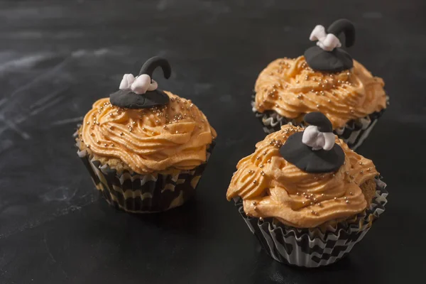 Feliz Halloween naranja y cupcake negro decorado con un sombrero de bruja negro y crema de mantequilla con cuentas — Foto de Stock