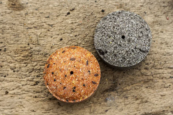 Round briquettes of pressed flax seed and sunflower seed. It is used as feed for animals, birds and fish. One of the feed ingredients — Stock Photo, Image