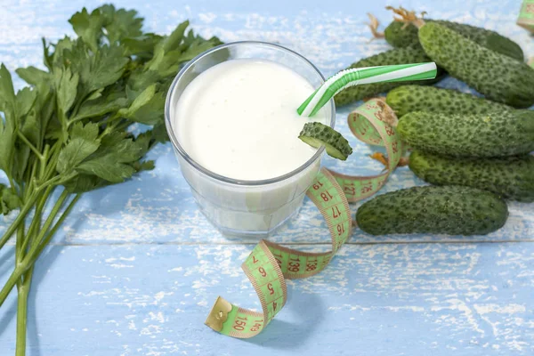 Ayran, ev yapımı yoğurt içeceği, kefir, salatalık ile lassi - mavi bir arka plan üzerinde sağlıklı yaz ferahlatıcı soğuk içecek. Kilo kaybı ve sağlıklı beslenme kavramı.