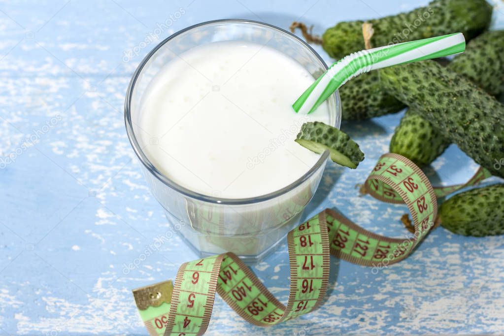 Ayran, homemade yogurt drink, kefir, lassi with cucumbers - healthy summer refreshing cold drink on a blue background. The concept of weight loss and healthy eating.