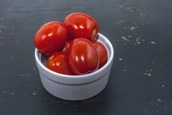 Comida fermentada em uma placa cinza em uma mesa de madeira preta. Tomates em conserva. Sal para o inverno. Lanche tradicional de álcool . — Fotografia de Stock