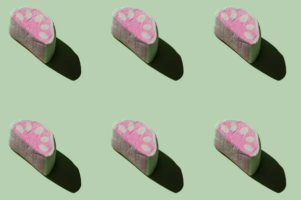 Pastel yeşil arka planda koyu gölgeli leziz marşmelovlar.