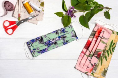 Hafif ahşap bir masada el yapımı kumaştan yapılmış yeniden kullanılabilir koruyucu tıbbi maskeler..