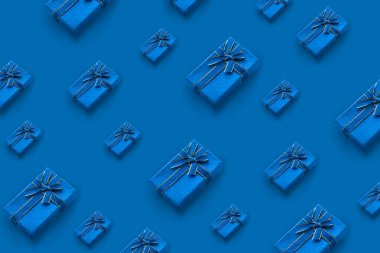 Mavi arka planda bir kurdeleyle bağlanmış hediye kutularının deseni.