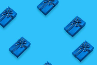 Açık mavi arkaplan ve kopyalama alanı olan bir kurdele ile bağlanmış hediye kutularının deseni.