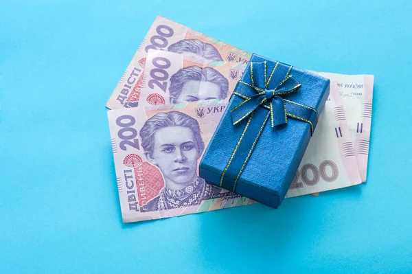 Banknotların üzerinde mavi bir hediye kutusu var. Ukrayna 'da alışveriş kavramı.