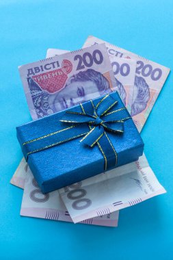 Hediye kutusu koruyucu bir maske ve birkaç banknot üzerinde duruyor. Ukrayna 'da koronavirüs döneminde alışveriş kavramı.