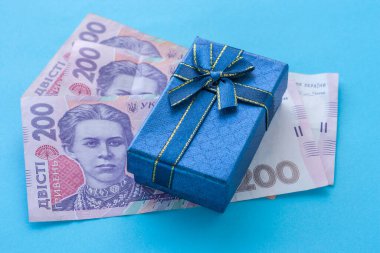 Hediye kutusu koruyucu bir maske ve birkaç banknot üzerinde duruyor. Ukrayna 'da koronavirüs döneminde alışveriş kavramı.