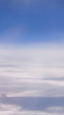 Bulutların sakin hava manzarası ve uçaktan mavi gökyüzü.