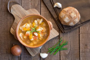 Ahşap masa üzerinde ekmek ve yeşil soğan ile sebze çorbası