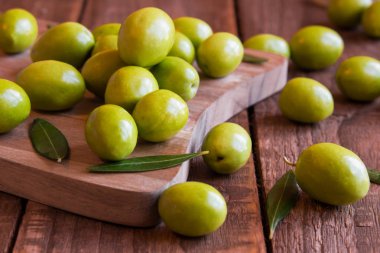 Koyu ahşap zemin üzerine taze yeşil zeytin