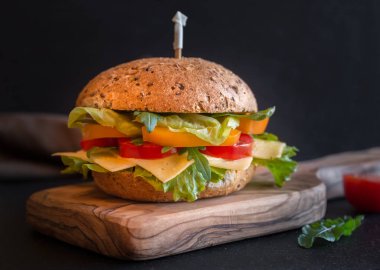 Peynirli, marullu, sebzeli ve roka arkaplanlı lezzetli sandviç.