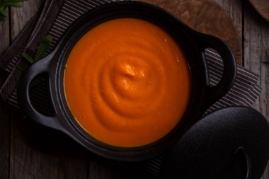 Sıcak balkabağı çorbası. Koyu ahşap tencerede.