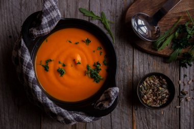 Sıcak balkabağı çorbası. Koyu ahşap tencerede.