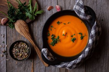 Sıcak balkabağı çorbası. Koyu ahşap tencerede.