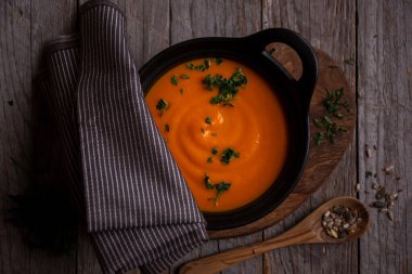 Sıcak balkabağı çorbası. Koyu ahşap tencerede.