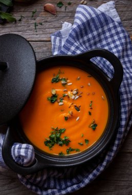 Sıcak balkabağı çorbası. Koyu ahşap tencerede.