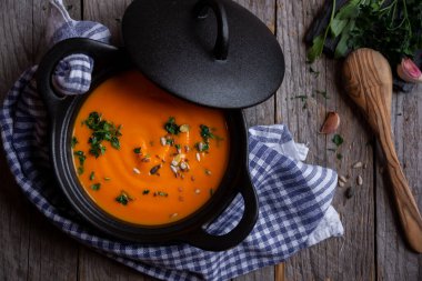 Sıcak balkabağı çorbası. Koyu ahşap tencerede.