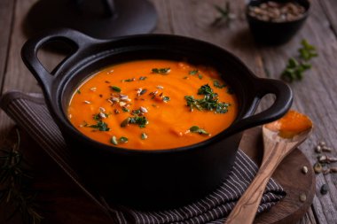 Sıcak balkabağı çorbası. Koyu ahşap tencerede.