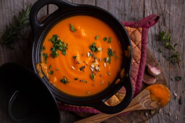 Sıcak balkabağı çorbası. Koyu ahşap tencerede.