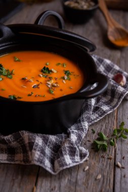 Sıcak balkabağı çorbası. Koyu ahşap tencerede.