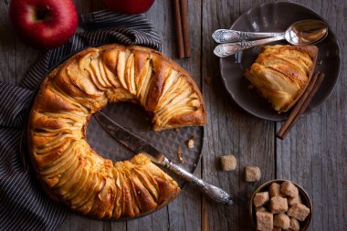 Dilimlenmiş elma ve kahverengi şekerli ev yapımı lezzetli elmalı turta