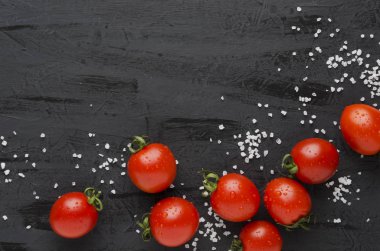 Lezzetli taze domates ve siyah masada tuz