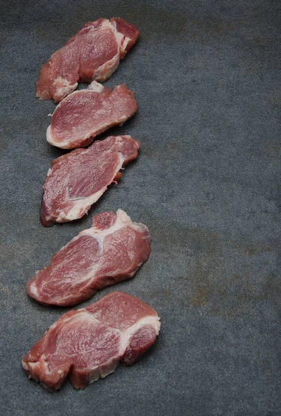 Satır taze domuz eti mutfak gri masada parçaları