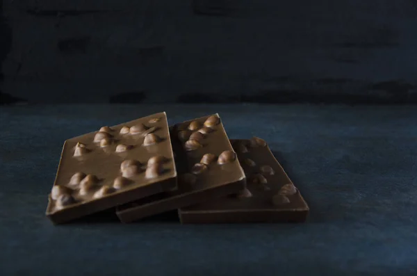 青の背景にヘーゼル ナッツとダーク チョコレート — ストック写真
