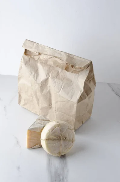垂直拍摄 生态袋与新鲜和美味的不同种类的奶酪在白色大理石桌子上 — 图库照片