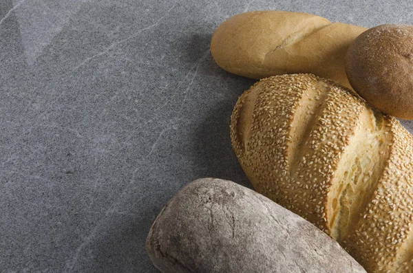 Assortment of delicious bread on gray stone table in the kitchen