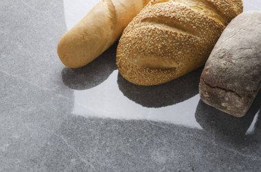 Çavdar ekmeği, ekmek sesam tohumlar, baget gri taş yüzeyi