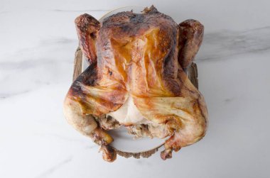 Kızarmış tavuk üstten görünüm plaka ve ahşap kesme tahtası, beyaz masa mutfak