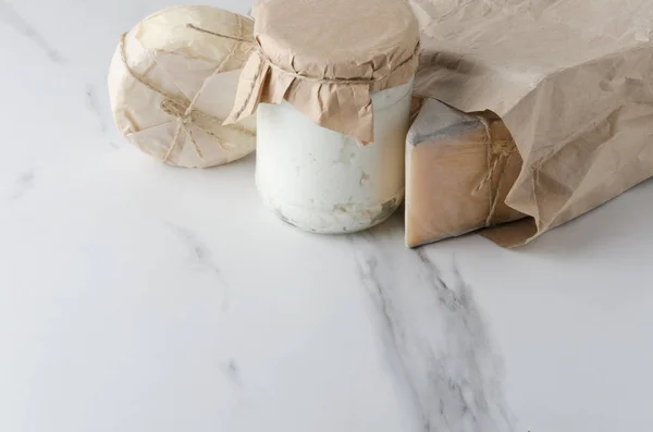 Diferentes Tipos Queijo Saco Papel Mesa Mármore Branco Cozinha — Fotografia de Stock
