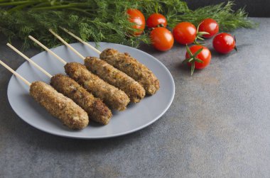 Izgara lule Kebap gri plaka, taze domates, dereotu karanlık mutfak masasında demet. Metin için boş alan