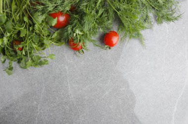 Üstten görünüm dekoratif kurulu dereotu, kişniş ve gri mutfak masa üstü taze domates ile yaptı. Boş alan