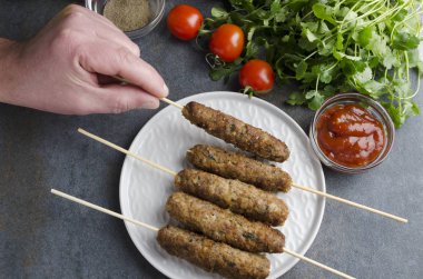 Erkek el satsebeli sosu, üstten görünüm sınama lule kebap lezzetli bir parça alarak