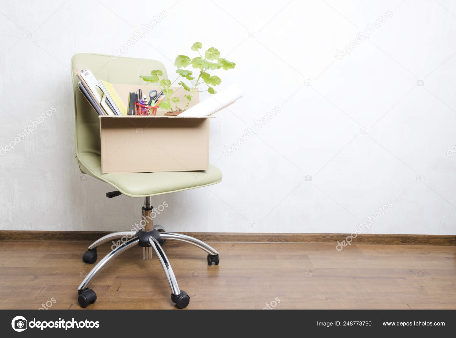 box with personal items standing on the chair in the officeconcept of  moving or dismissal 248773790