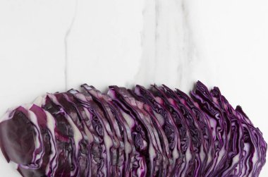 Satır doğranmış kırmızı lahana beyaz mutfak masasında, üstten görünüm