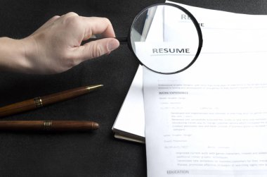Recruiter iş yeri, özgeçmiş örnekleri, kırtasiye, el Büyüteç tutarak yığını