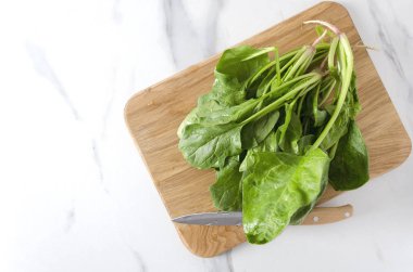 Mermer masada ahşap tahta üzerinde üstten görünüm sulu ıspanak. Organik salata, kopya alanı yapmak için hazırlık